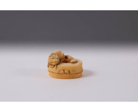 A JAPANESE NARWHAL TUSK NETSUKE MEIJI ERA, 19TH CENTURY Carved as a small tiger crouching on a section of bamboo, its long ta