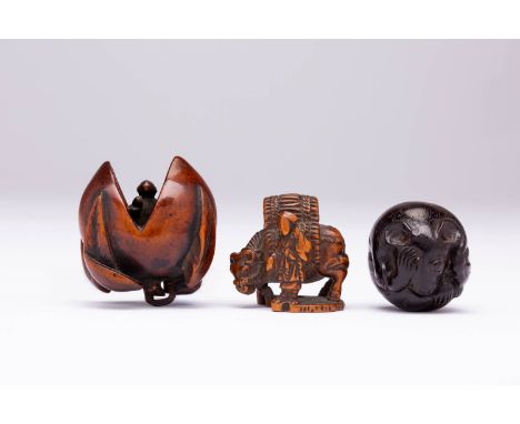 THREE JAPANESE WOOD NETSUKE MEIJI ERA, 19TH CENTURY Variously carved as a small rat gnawing on the base of its tail, one eye 