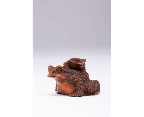 A JAPANESE BOXWOOD NETSUKE OF TWO TOADS MEIJI ERA, 19TH CENTURY One smaller amphibian clambering on the back of the other, th