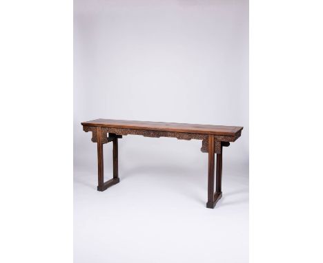 A CHINESE HARDWOOD SCROLL TABLE LATE QING DYNASTY The long rectangular top above a frieze, carved in relief with lotus foliag