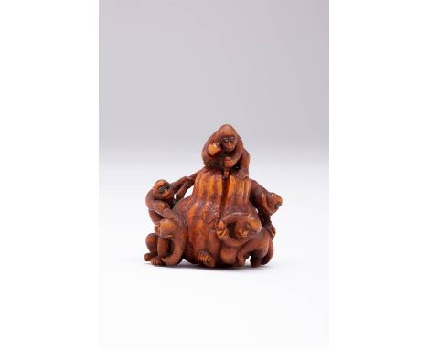 A JAPANESE WOOD NETSUKE OF MONKEYS MEIJI ERA, 19TH CENTURY Carved as six primates playing around a large double-gourd, a seve