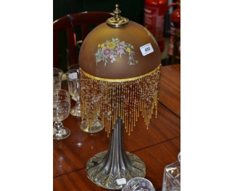 A silvered metal Art Nouveau style table lamp, amber glass shade with beads