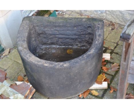 A stone D shaped planter/trough