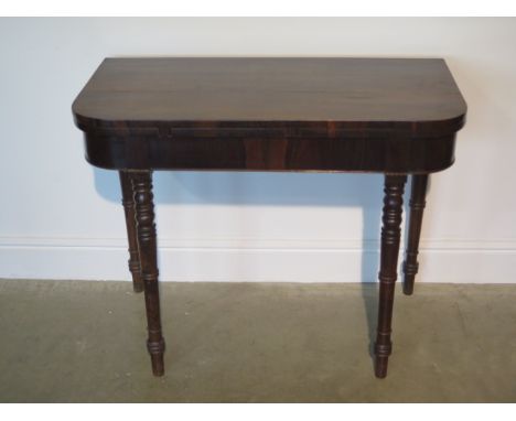 A 19th century rosewood fold over card table on turned supports, 74cm tall x 92cm 