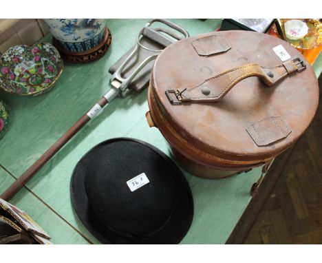 A leather hat box containing a French top hat, a Dunn &amp; Co bowler hat plus a shooting stick