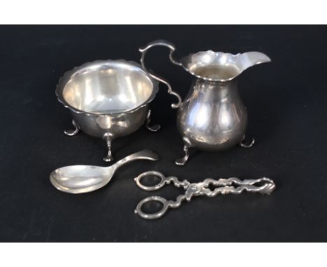 A silver cream jug, sugar bowl, nips and a caddy spoon