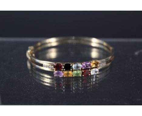 A 9ct gold 'Tutti Frutti' bangle set with multi coloured gemstones