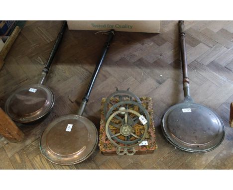 Three Victorian copper warming pans, three brass trivets plus a foot warmer in inlaid box stool