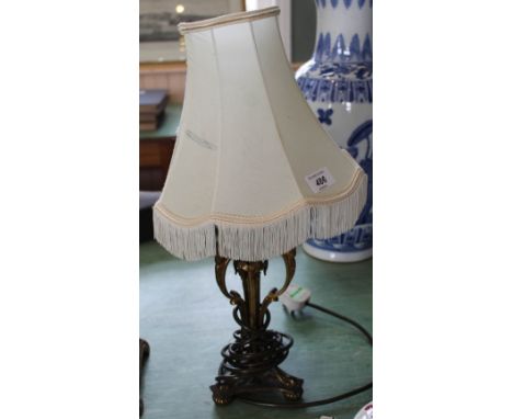 A brass table lamp with rams head decoration