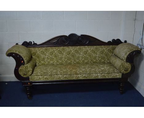 A REGENCY MAHOGANY FOLIATE SCROLLED SOFA, with roundels to the back, on turned legs with brass caps and casters, width 224cm 