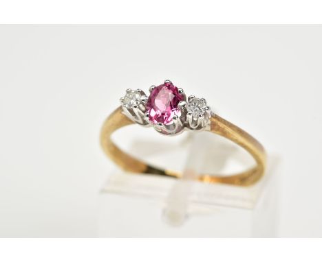 A 9CT GOLD TOURMALINE AND DIAMOND RING, designed with a central oval claw set pink tourmaline flanked with round brilliant cu