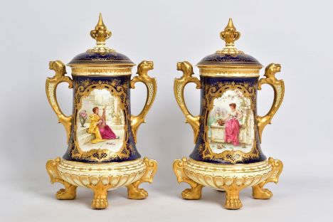 A PAIR OF EARLY 20TH CENTURY COALPORT TWIN HANDLED URNS AND COVERS WITH HAND PAINTED PANELS OF MAIDENS, SIGNED BY J KEELING, 