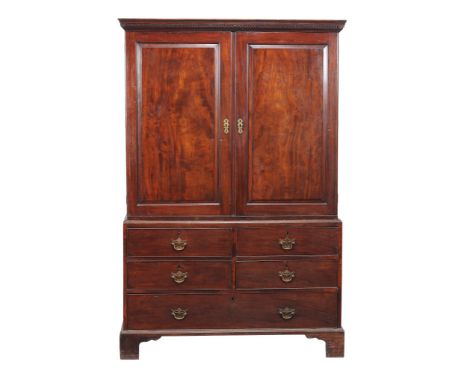  A George III mahogany linen press,   circa 1760, the panel doors enclosing slides, above a base with four short and one long