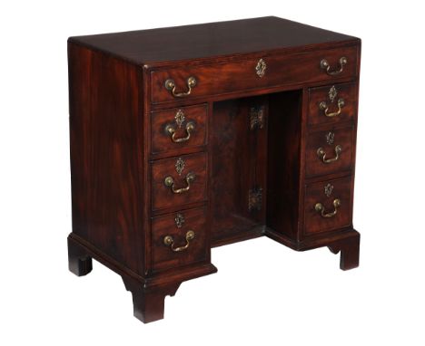  A George III mahogany kneehole desk,   circa 1780, the rectangular caddy moulded top above an arrangement of seven drawers c