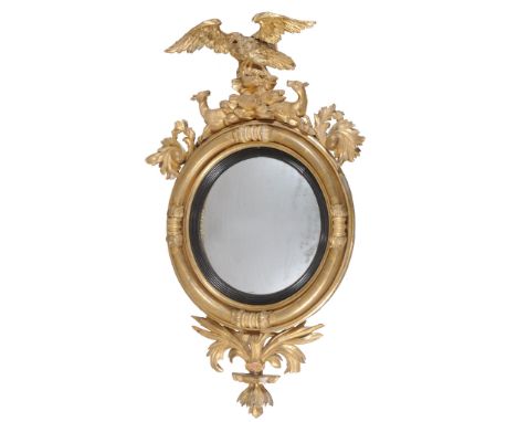  A George III carved giltwood circular convex wall mirror,   circa 1810, the circular plate within an ebonised sight edge and