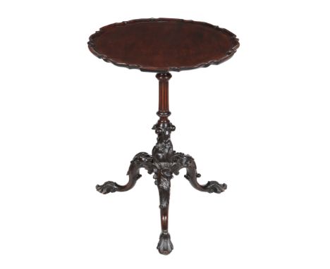  A mahogany tripod table,   first half 19th century, the circular shaped top with pie crust edge above a turned and fluted st
