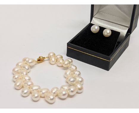 A pearl bracelet with a pair of pearl earrings. Measurements of bracelet open 17cm 
