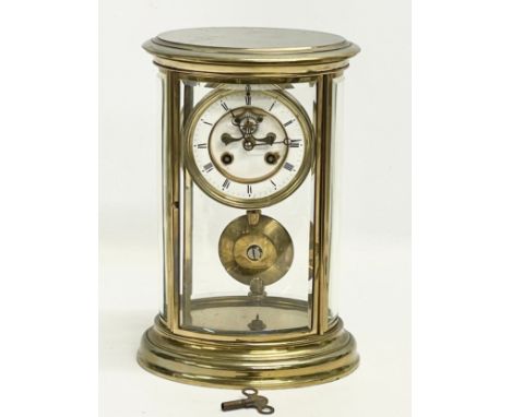 A large late 19th century French oval brass mantle clock with 4 bevelled glass panels and key. Stamped HP &amp; Co. 19x15x30c