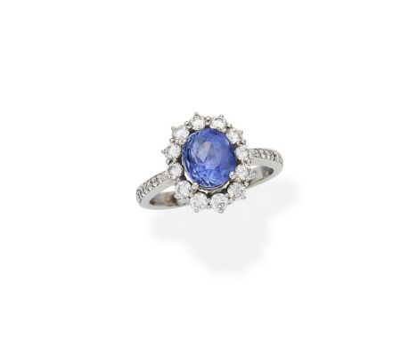 Sapphire and diamond cluster ringThe oval-cut sapphire within a surround of brilliant-cut diamonds, between similarly-set dia