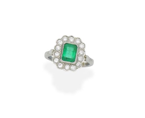 Emerald and diamond cluster ringThe step-cut emerald within a scalloped surround of brilliant-cut diamonds, mounted in 18 car