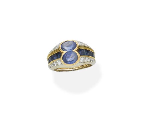 Sapphire and diamond ringOf bicoloured design, set with two oval-cut sapphires between tapering shoulders of step-cut sapphir