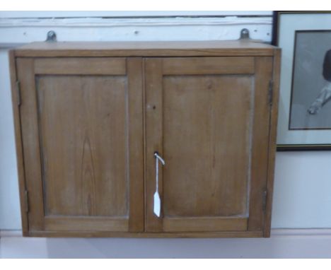A Victorian Pine Wall Cupboard, with two panel doors, single interior shelf and lock and key, approx 58 x 19 x 44 cms.