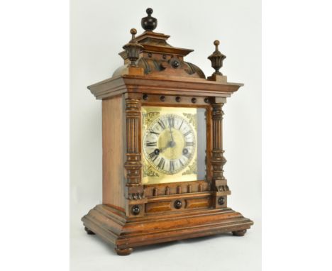 An early 20th century German oak 14 day strike cased mantle clock. The clock featuring carved urn finials over square cased c