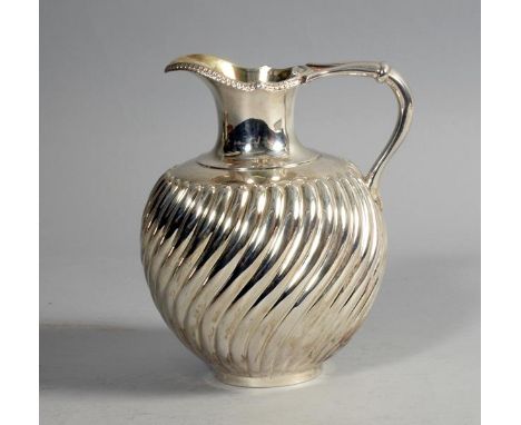 A late Victorian water jug of wrythen lobed globular form, having a pronounced pouring spout, hinged cover and scroll handle,