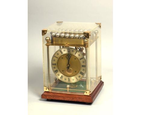 A mid 20c novelty mantel clock by Thwaites and Reed where the single train movement is powered by the weight of a line of bal