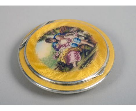 An Edwardian white metal and combed yellow enamel compact  of circular form, the hinge cover painted with a circular panel de
