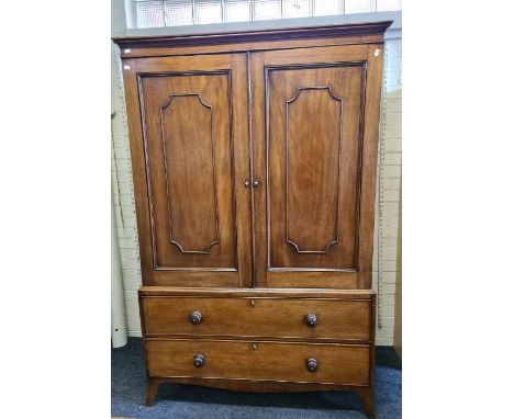 A George III mahogany linen press, the moulded cornice over a pair of fielded panel doors with brass acorn covered escutcheon