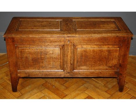 An 18th century oak panel coffer, oblong outline raised on block feet, W104.5cm