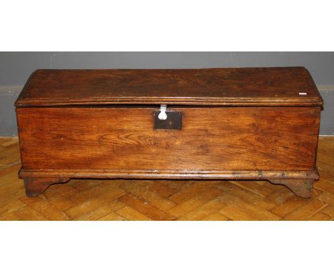 A late 17th century oak panel coffer of narrow proportions raised on cut panel dual end supports, W115cm