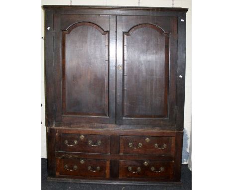 An early 18th century oak livery cupboard, the moulded cornice above a pair of fielded arched panel doors enclosing later han