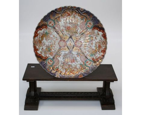 A large 19th century Imari porcelain charger decorated in gilt heightened polychrome enamel with four reserve panel of flower