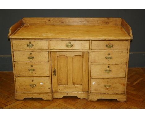 A late 19th / early 20th century pine kitchen dresser, the ledge back over three frieze drawers and a panel door flanked to e