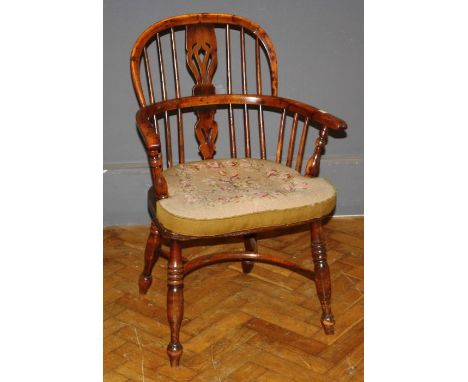 A mid 19th century ash and yew Windsor elbow chair, the comb back over a panel seat raised on turned legs