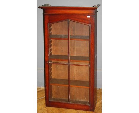 A mahogany shallow wall cabinet enclosed by a glazed full length panel door, H117cm