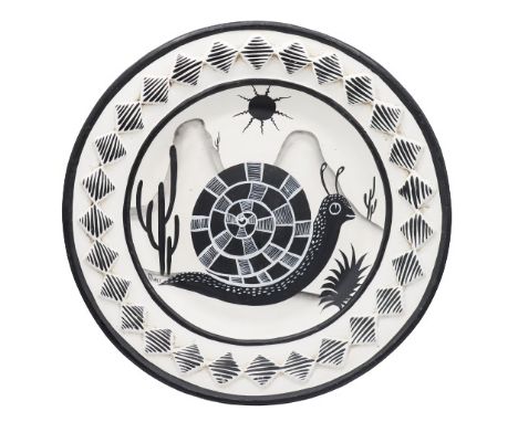 Large painted ceramic decorative platter with a geometric snail design set against a Southwestern landscape; raised diamond s