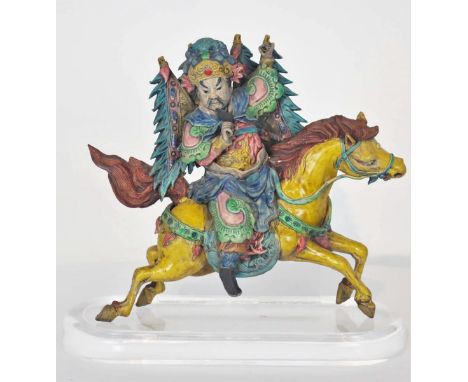 Bearded figure on running horse. Ceramic tiles such as this one have been placed on Chinese temple roofs for centuries to war