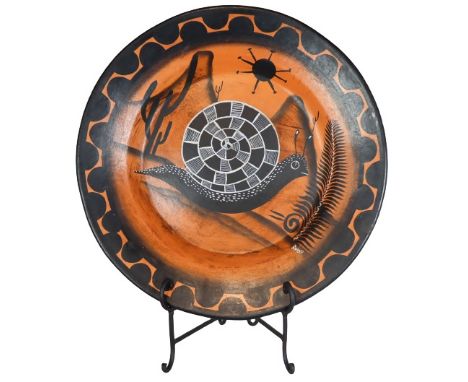 Very large painted orange and black ceramic decorative platter, with a geometric snail design set against a Southwestern land