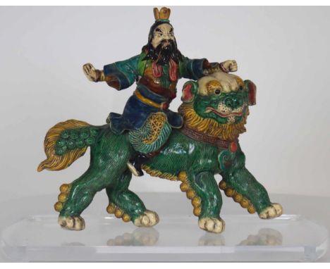 Bearded figure riding a four-legged animal, perhaps a foo dog. Ceramic tiles such as this one have been placed on Chinese tem
