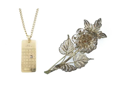 A 9CT GOLD AND DIAMOND SET DATE OF BIRTH CALENDAR PENDANT WITH A NECKCHAIN AND A BROOCH (3)The pendant mounted with a circula