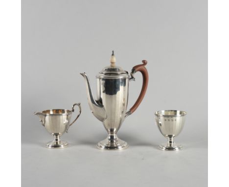 AN ART DECO SILVER THREE PIECE COFFEE SET (3)Comprising; a coffee pot with wooden fittings, a milk jug and a sugar bowl, each