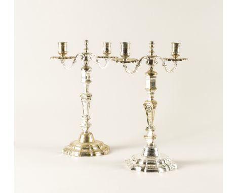 A PAIR OF PLATED TWIN LIGHT TABLE CANDELABRA (2)Each cast in the rococo taste and raised on a shaped hexagonal foot, height 3