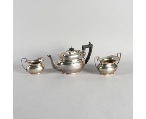 A SILVER THREE PIECE TEA SET (3)Comprising a teapot having black fittings, a twin handled sugar bowl and a milk jug, the teap