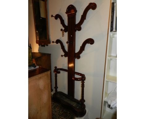 A late 19th / early 20th century mahogany hat and coat stand, in the Art Nouveau taste, having four scrolled arms and nine pe