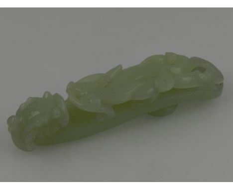 A Chinese celadon jade belt buckle, in the form of a dragon and leopard. L: 11cm