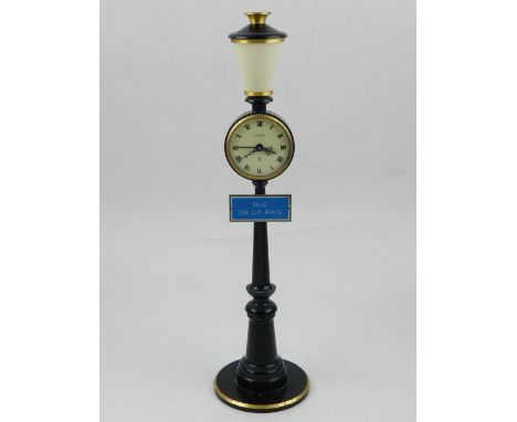 A Jaeger Rue De La Paix table clock, fashioned as a gilt, black and cream lacquered Paris street lamp, the enamel dial with R