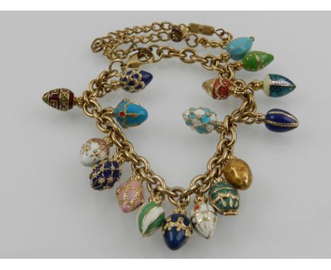 A yellow metal bracelet hung with various multi-coloured enamel eggs, in the Faberge style. 